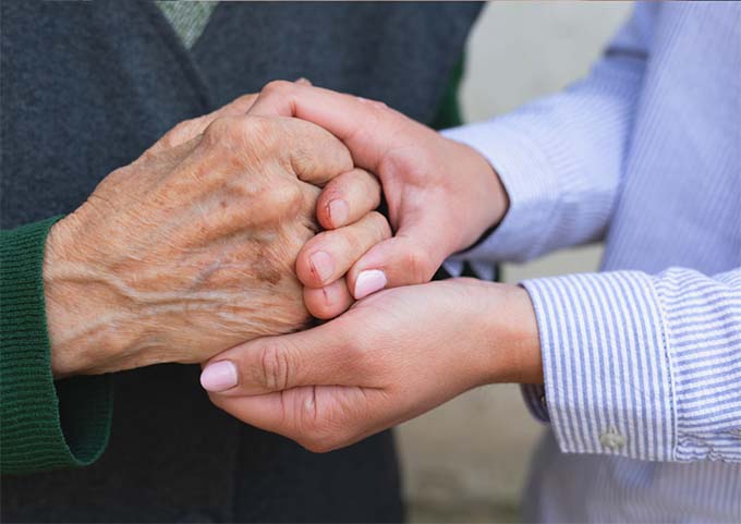 Two pairs of hands, one comforting the other